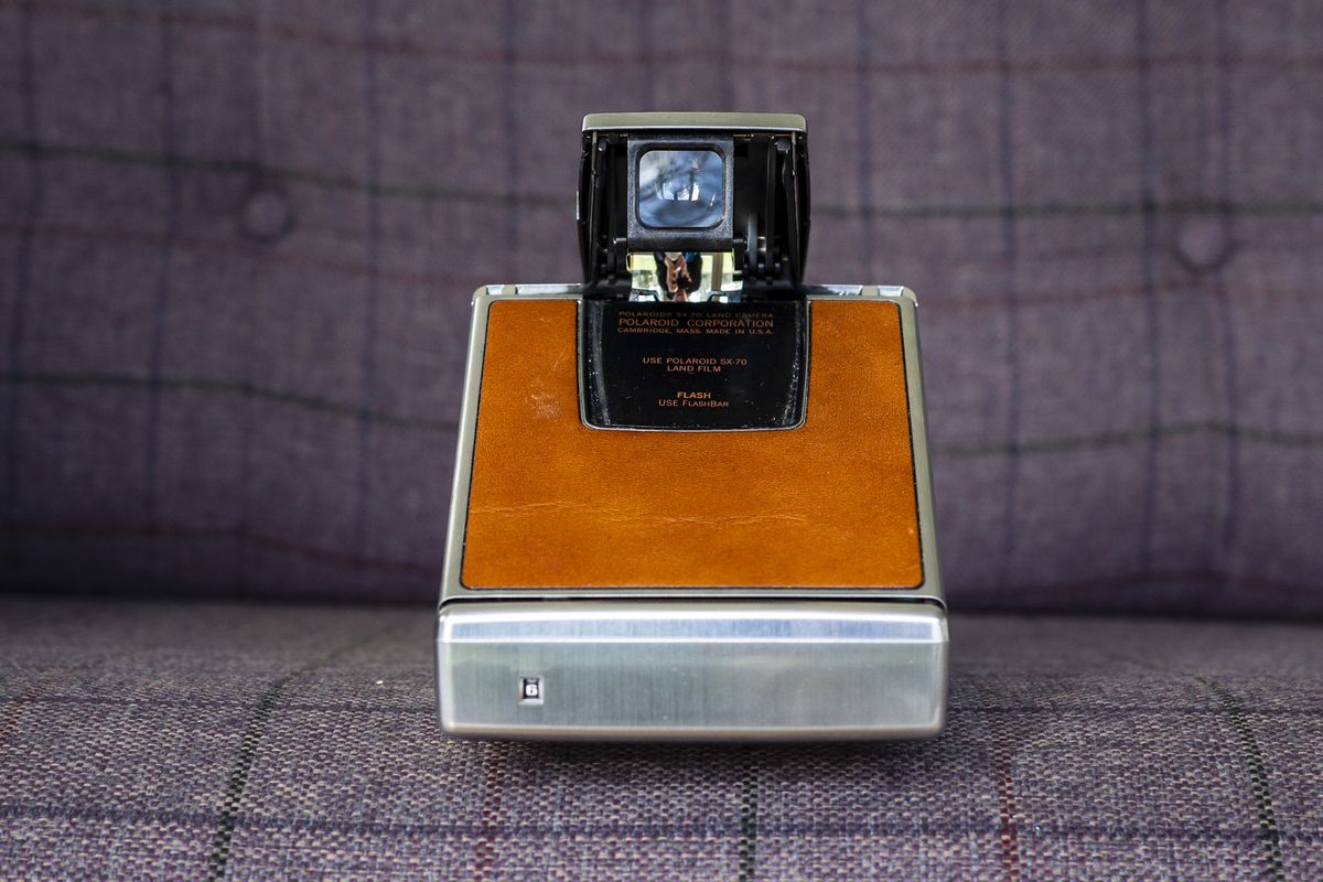Rear of Polaroid SX70 camera open in shooting position on purple chair