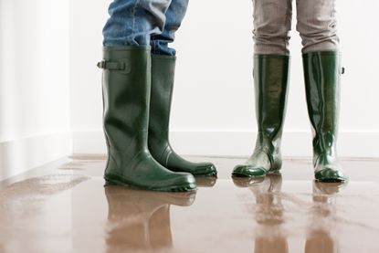 Young couple in wellington boots on flooded floor.