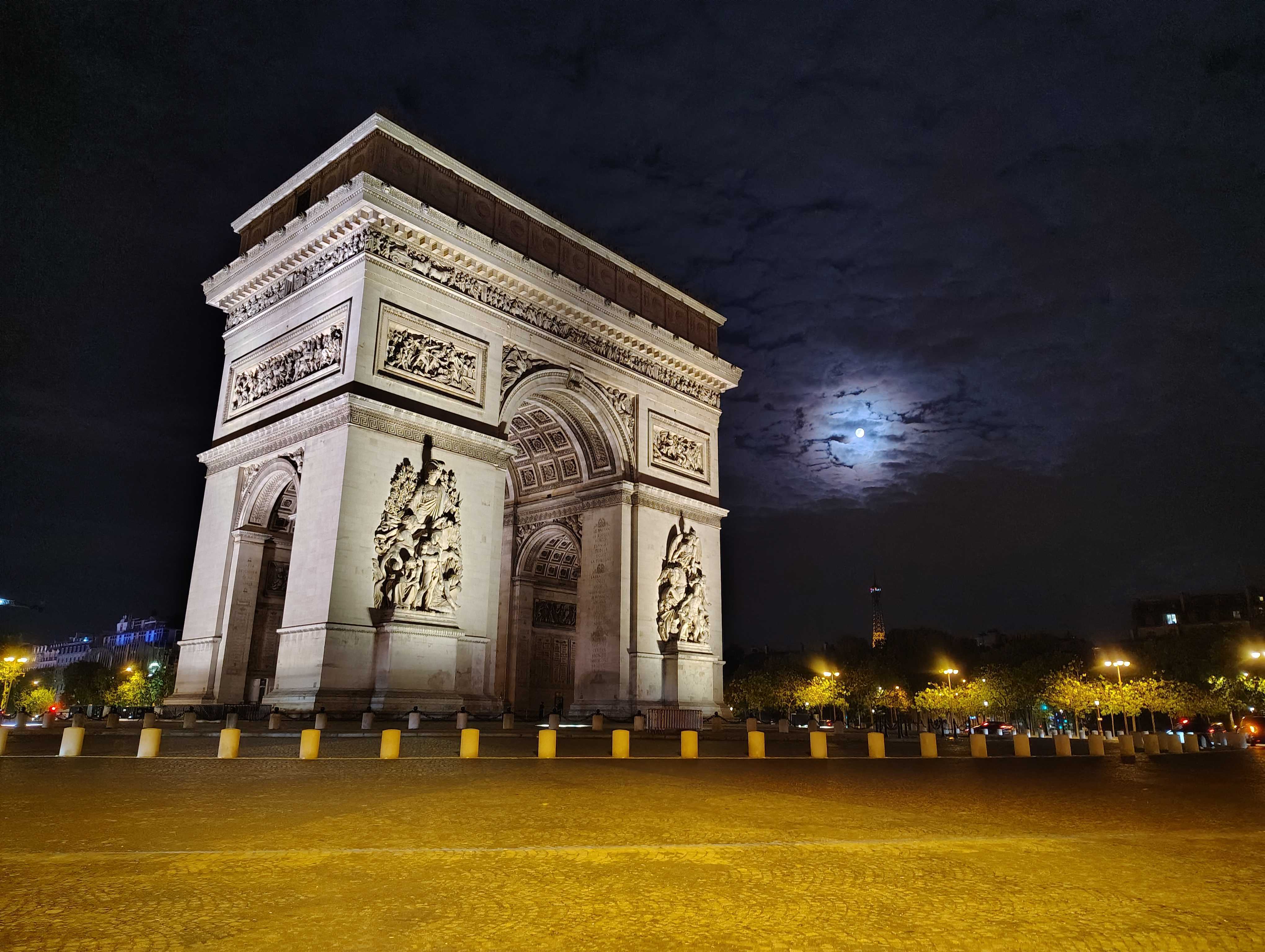 A large monument at night with the moon shining