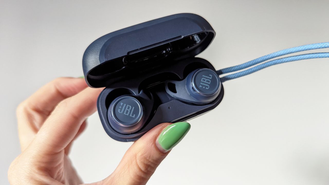 JBL Reflect Aero review: hand with green nails holding true wireless earbuds