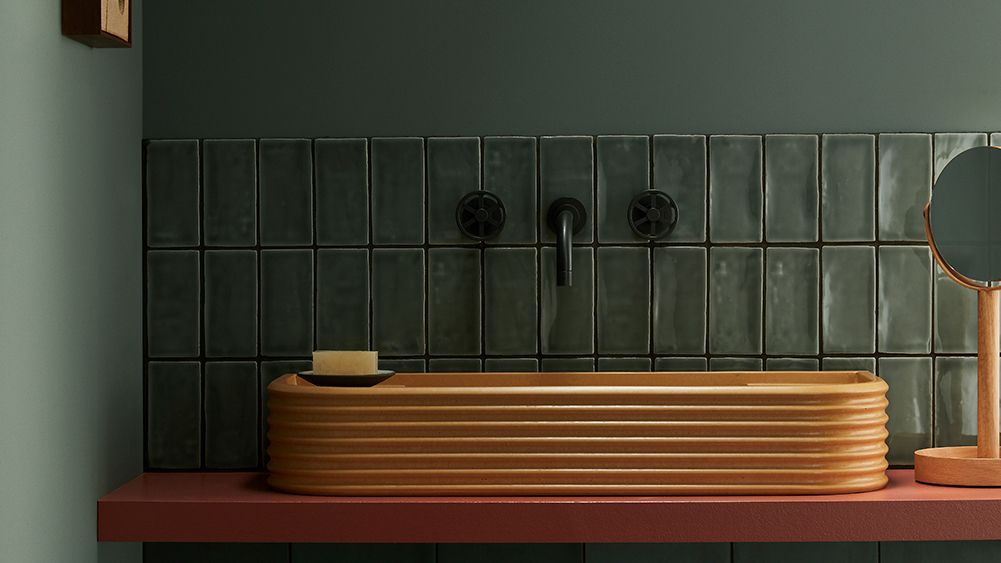 Small bathroom tile ideas A Bert and May bathroom featuring a terracotta sink and small bathroom tiles in dark green