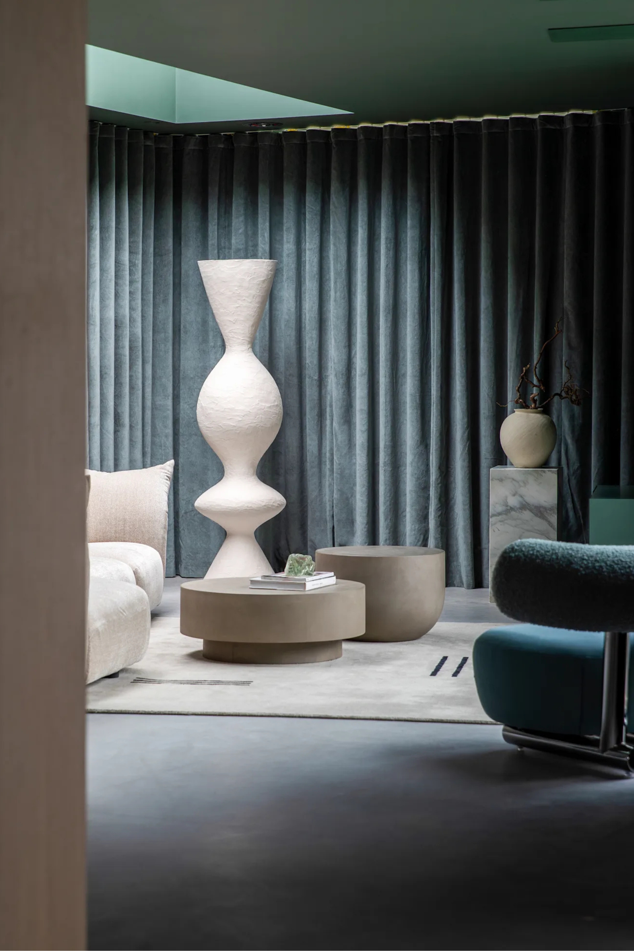 a living room with dark gray curtain, and a white sculptural object, and a green painted ceiling