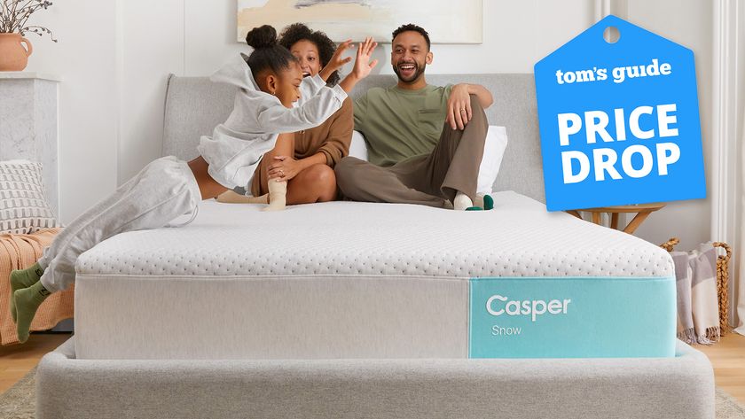 A Casper Snow hybrid cooling mattress in a bedroom, a man and woman sit on top of the mattress watching as a little girl jumps onto the bed, a Tom&#039;s Guide price drop deals graphic in the corner (right)