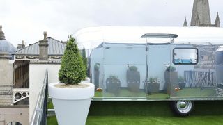 A silver airstream caravan on top of a roof