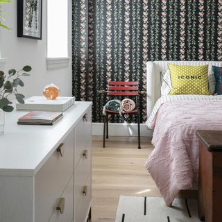 bedroom with black floral wallpaper and chest of drawers