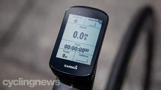 A black Garmin edge 830 mounted to the front of a bike, showing distance, heart rate, speed, a stopwatch, power and cadence showing on the display