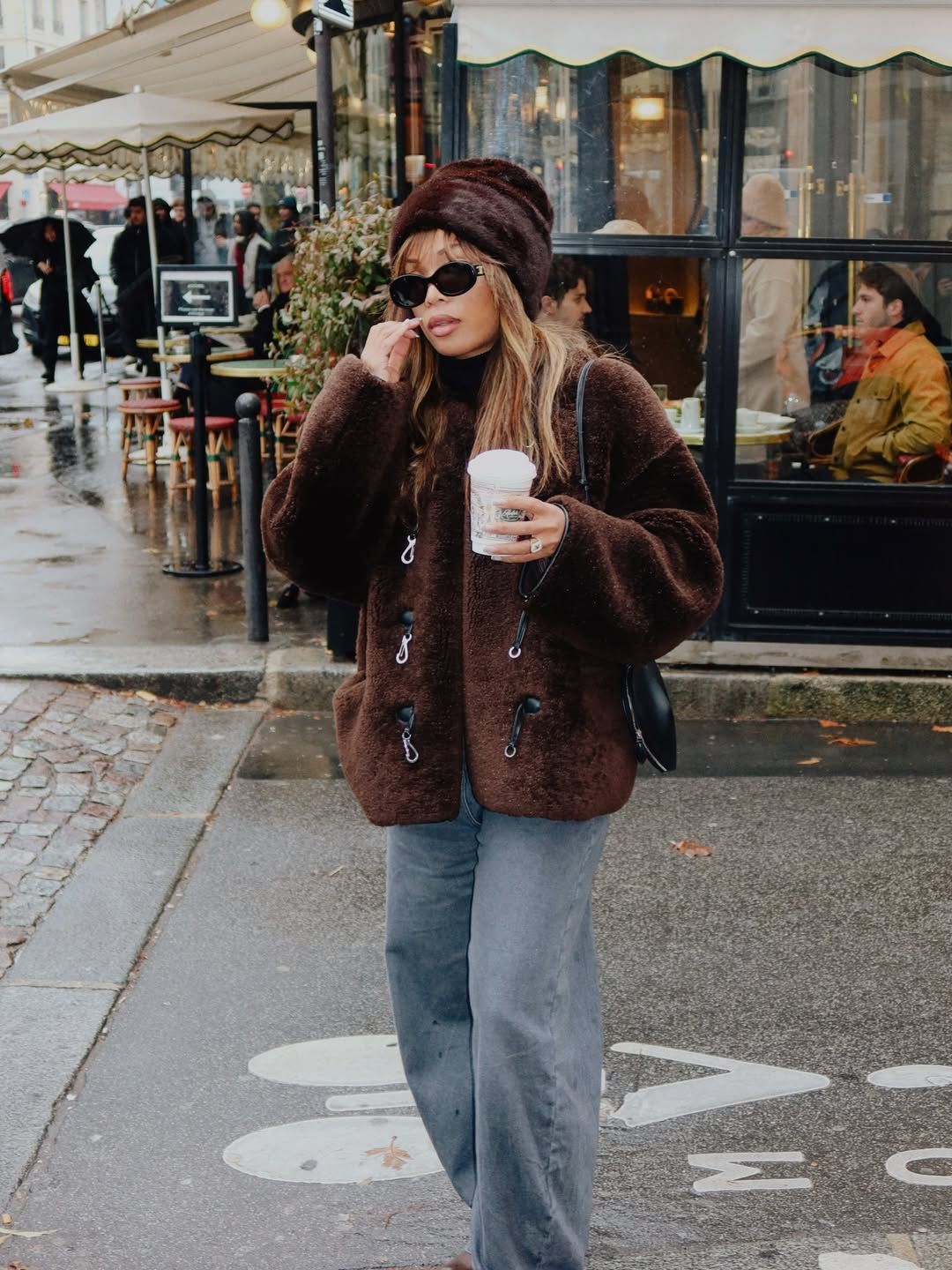 Ellie Delphine in a fuzzy jacket and matching hat.