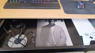 A light-brown FlexiSpot Comhar Pro Q8 standing desk with computer equipment on top of it.