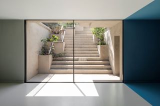 view through glazing to concrete steps up to garden