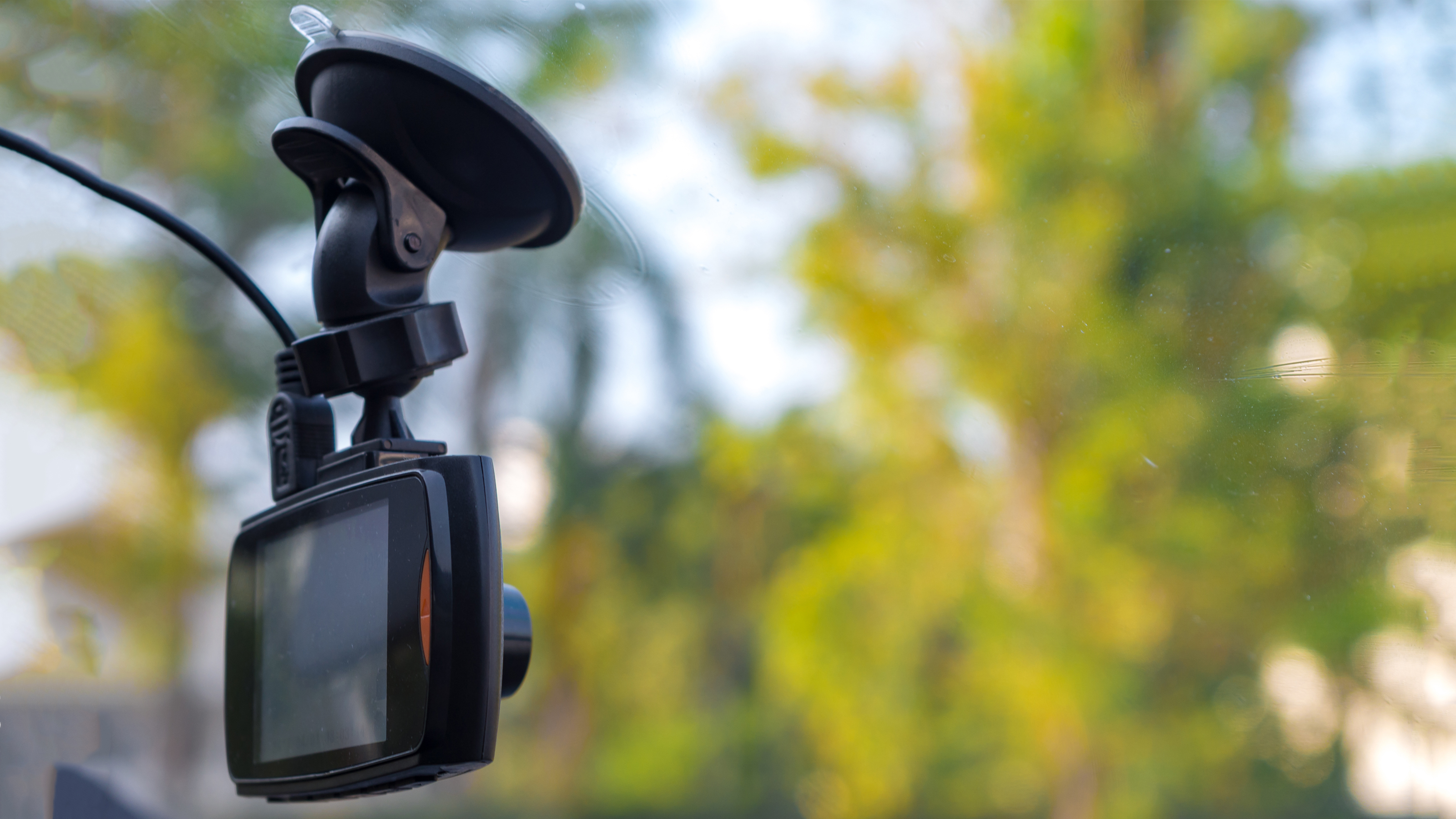 A dash cam mounted on a windshield using a suction mount