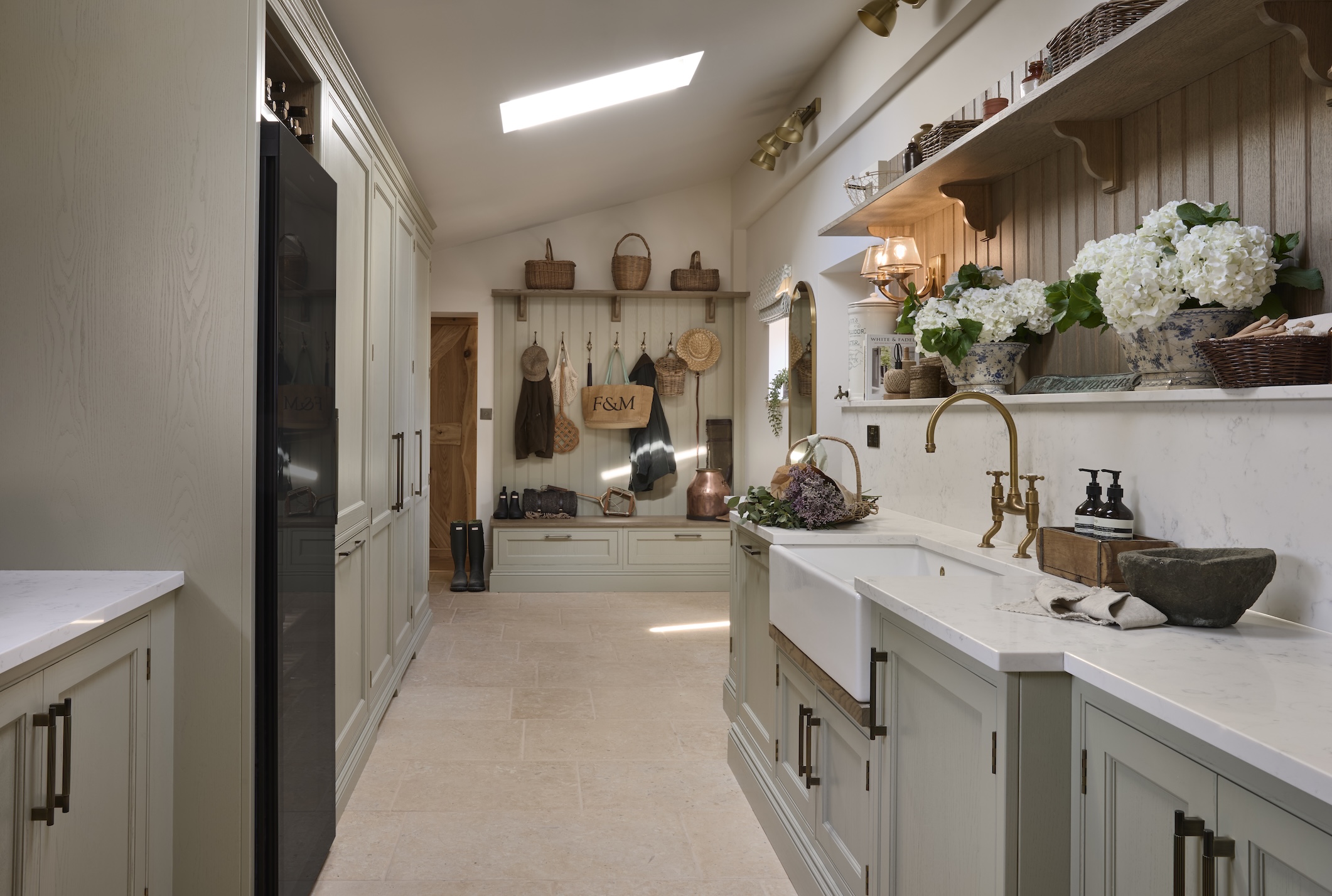 A traditional galley kitchen and boot room with a sky light above