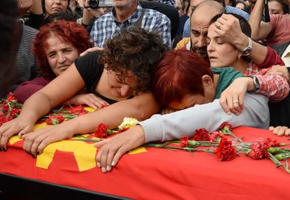 Family members of Korkmaz Tedik mourn over the coffin of the victim of suicide bomb blasts in Ankara, Turkey