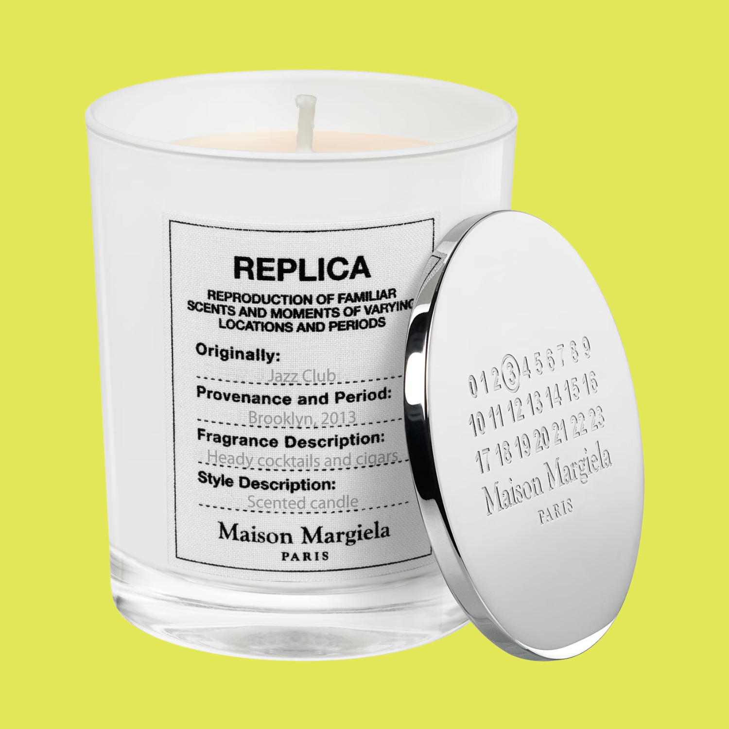 A glass candle with a silver lid