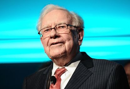 closeup of Warren Buffett onstage at the Forbes Media Centennial Celebration with a blue screen in the background