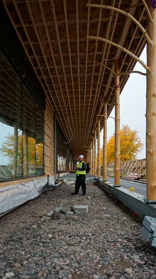 A man in a hi-vis vest and hard hat standing in the walkway during construction