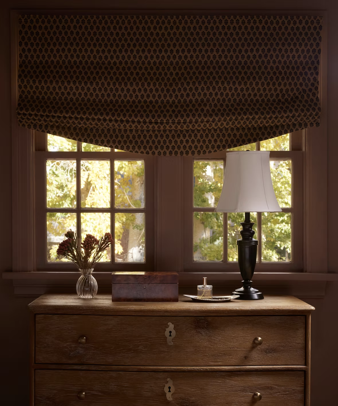 wood drawers in a window with flowers in a vase on top of it