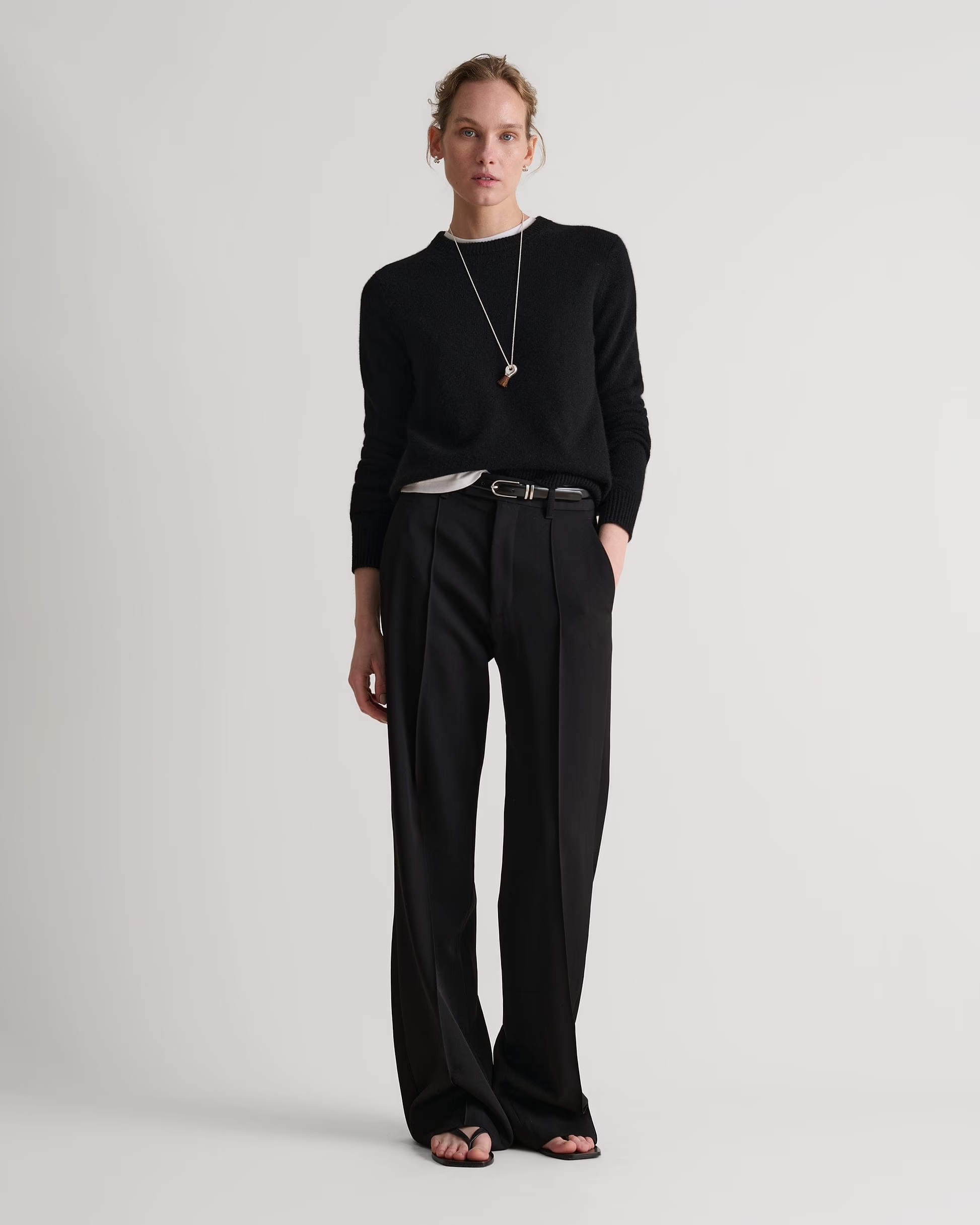 A model wearing a black crew neck Rise &amp;amp; Fall jumper.