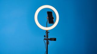 Godox 12-inch ring light photographed in front of a blue background with an iPhone on the phone mount.