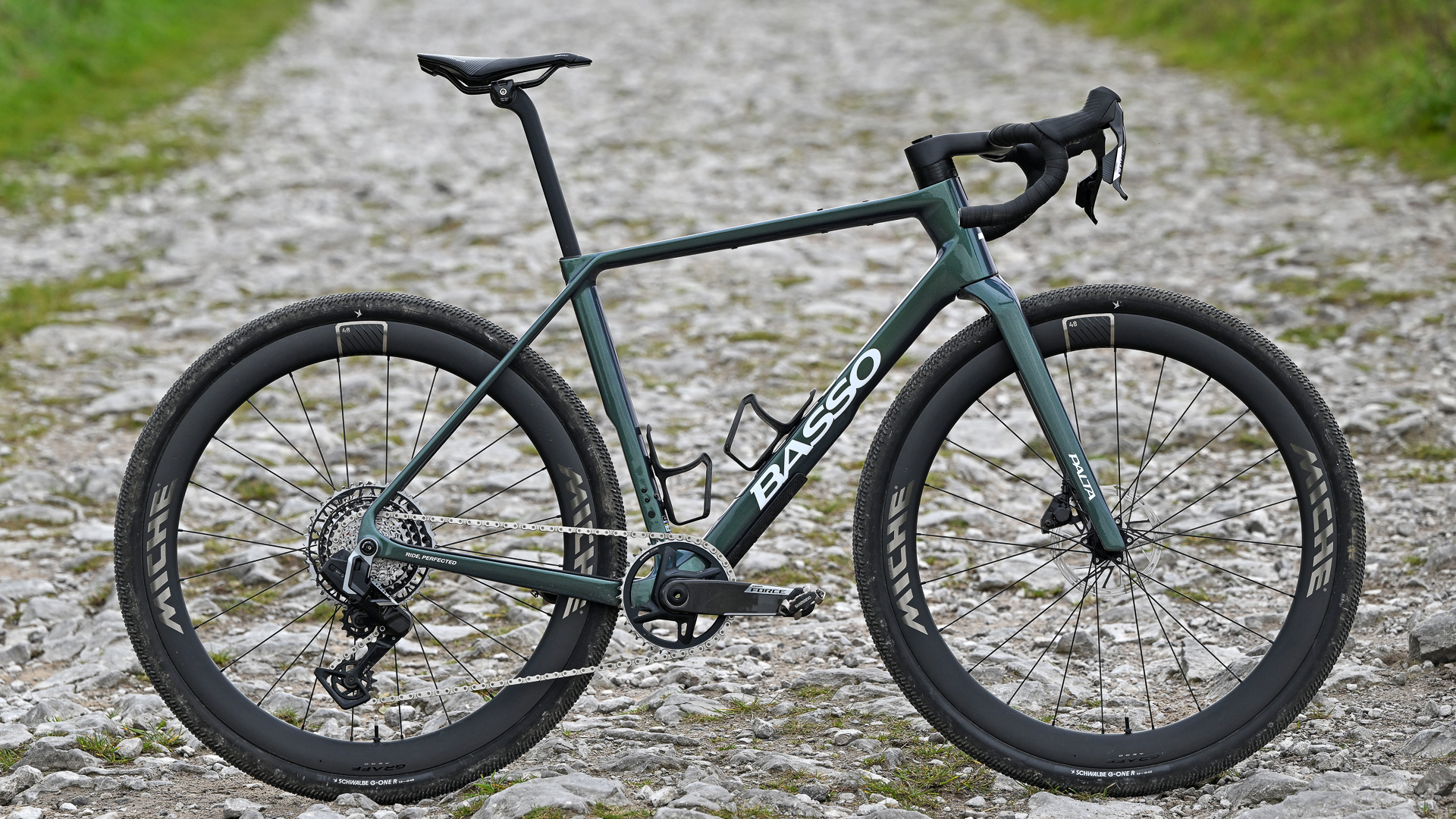 Green Basso Palta III gravel bike side on standing up on a limestone gravel track