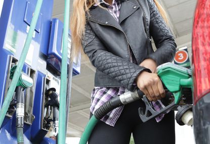 Woman refuelling her car at a petrol station