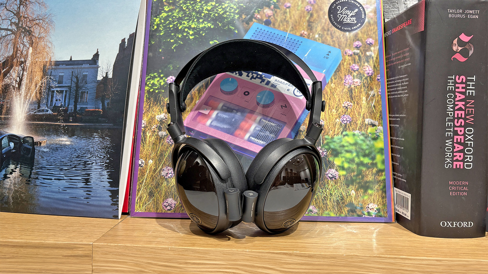 Yamaha YH-C3000 over-ear headphones on wooden bookshelf leaning up against vinyl record