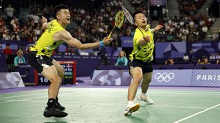 Taiwan's Wang Chi-lin and Lee Yang, in yellow t-shirts and black shorts, in the men's doubles badminton at the 2024 Paris Olympic Games.