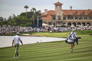 Scottie Scheffler walks down the fairway with his caddie