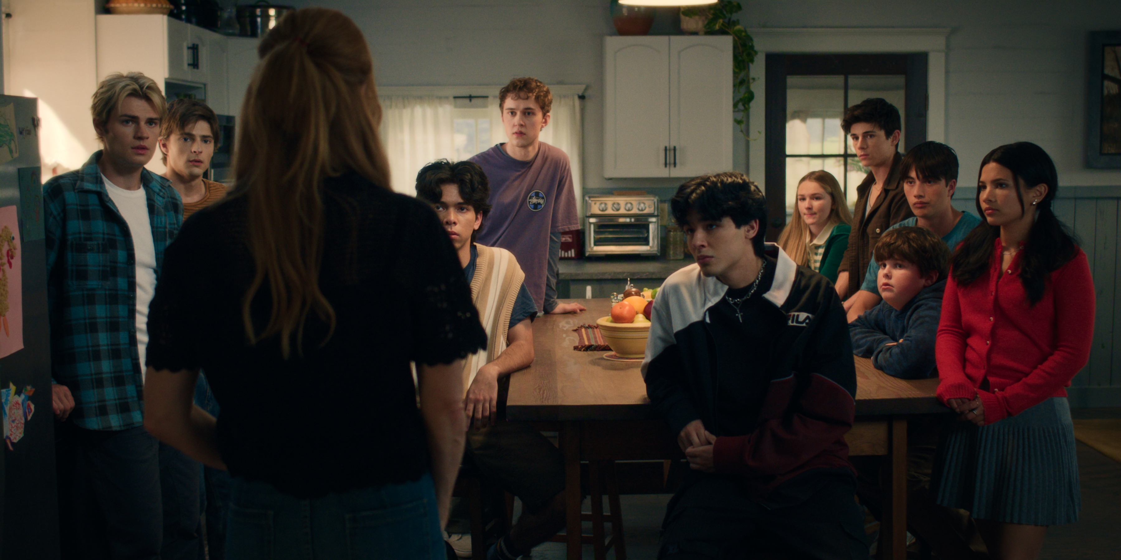 In a still from 'My Life with the Walter Boys,' a woman stands at the front of a room with 10 kids looking in her direction.