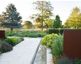 garden path running beside rill and surrounded by informal planting