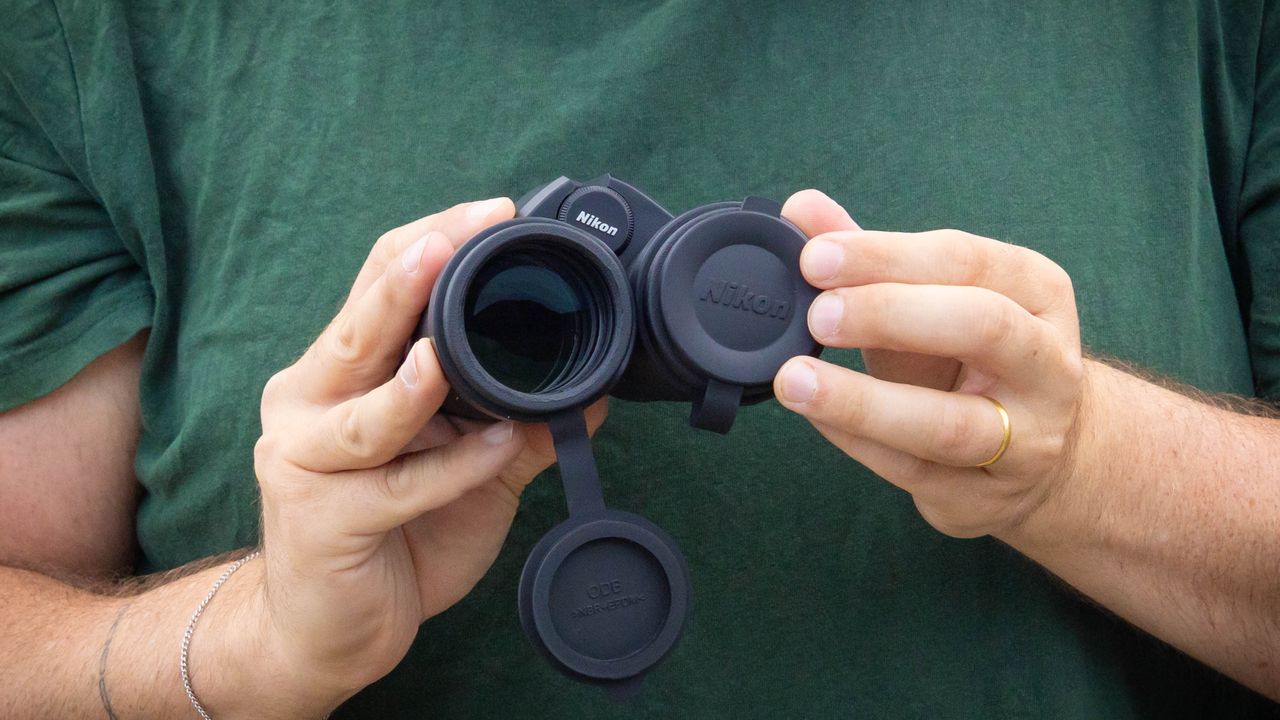 A person demonstrating the rubber lens caps on the Nikon Monarch M7 8x42 binoculars.