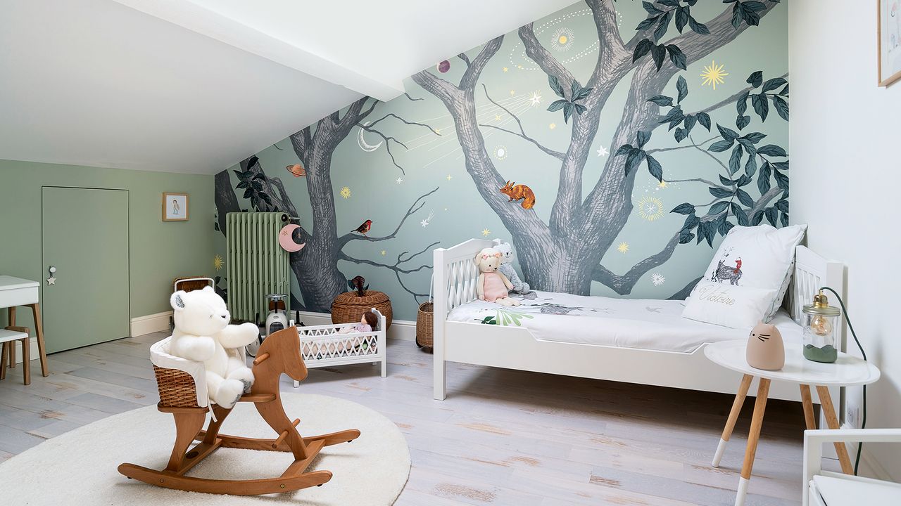 Attic nursery bedroom with woodland wall mural and rocking horse