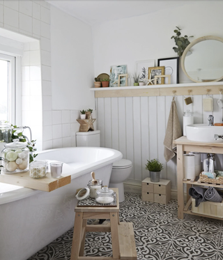 a small bathroom with freestanding bath, bathroom shelving and open cabinetry