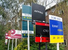 Various property signs outside a block of flats advertising homes for sale, let or sold.