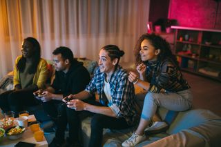A group of friends enjoying a video game on someone's home.
