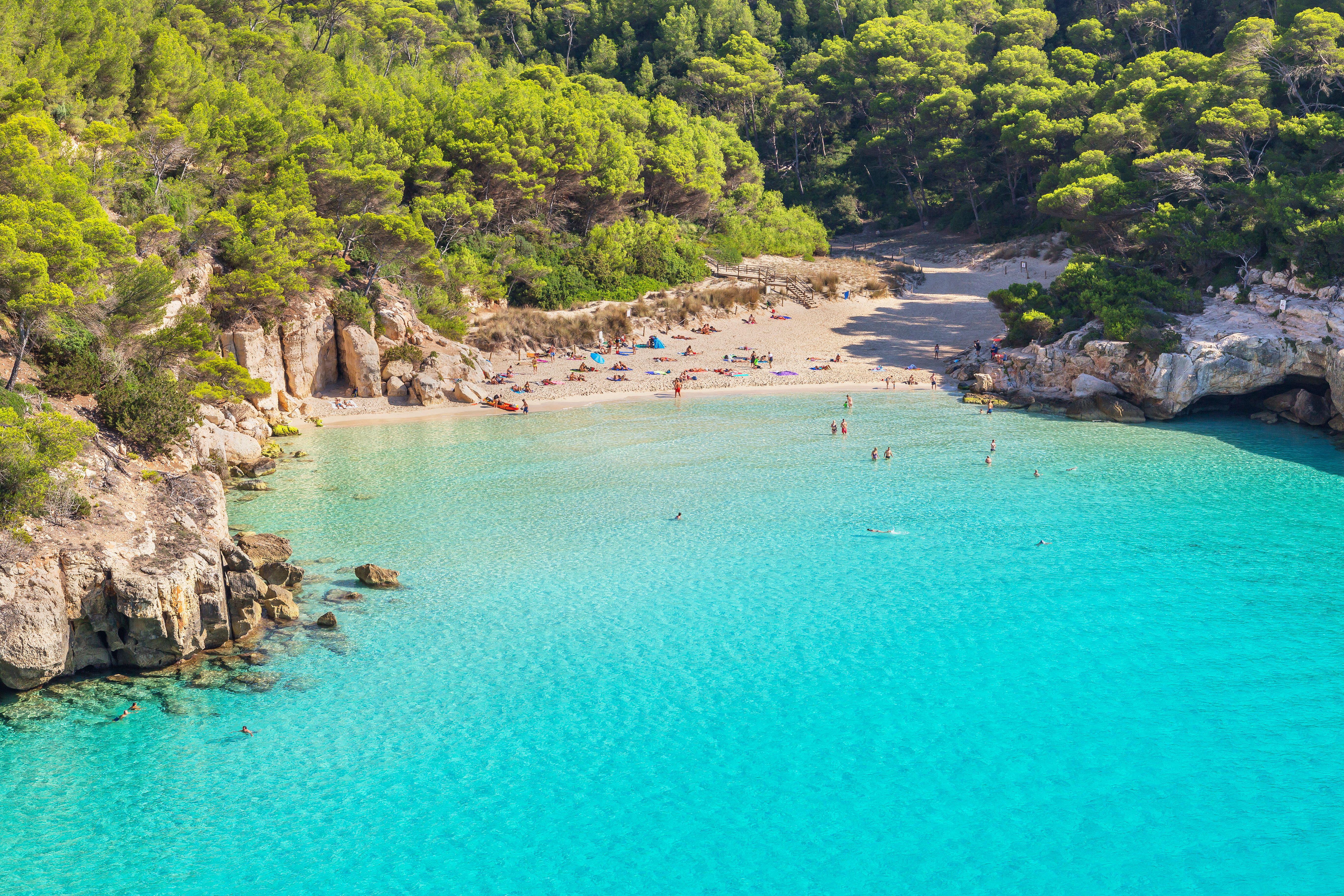 an aerial view from the sunny blue water menorcan beach Cala Mitjana