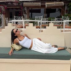 Woman lounging in an all white outfit.
