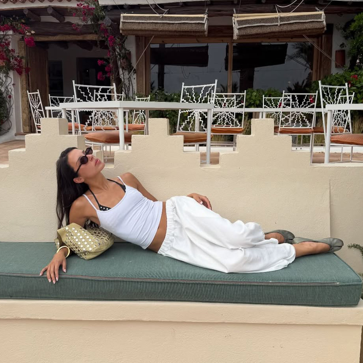 Woman lounging in an all white outfit. 