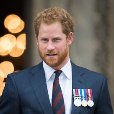 Prince Harry wearing a suit and military medals.