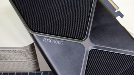 An RTX 5090 graphics card resting against its retail box with a closeup of the RTX 5090 branding