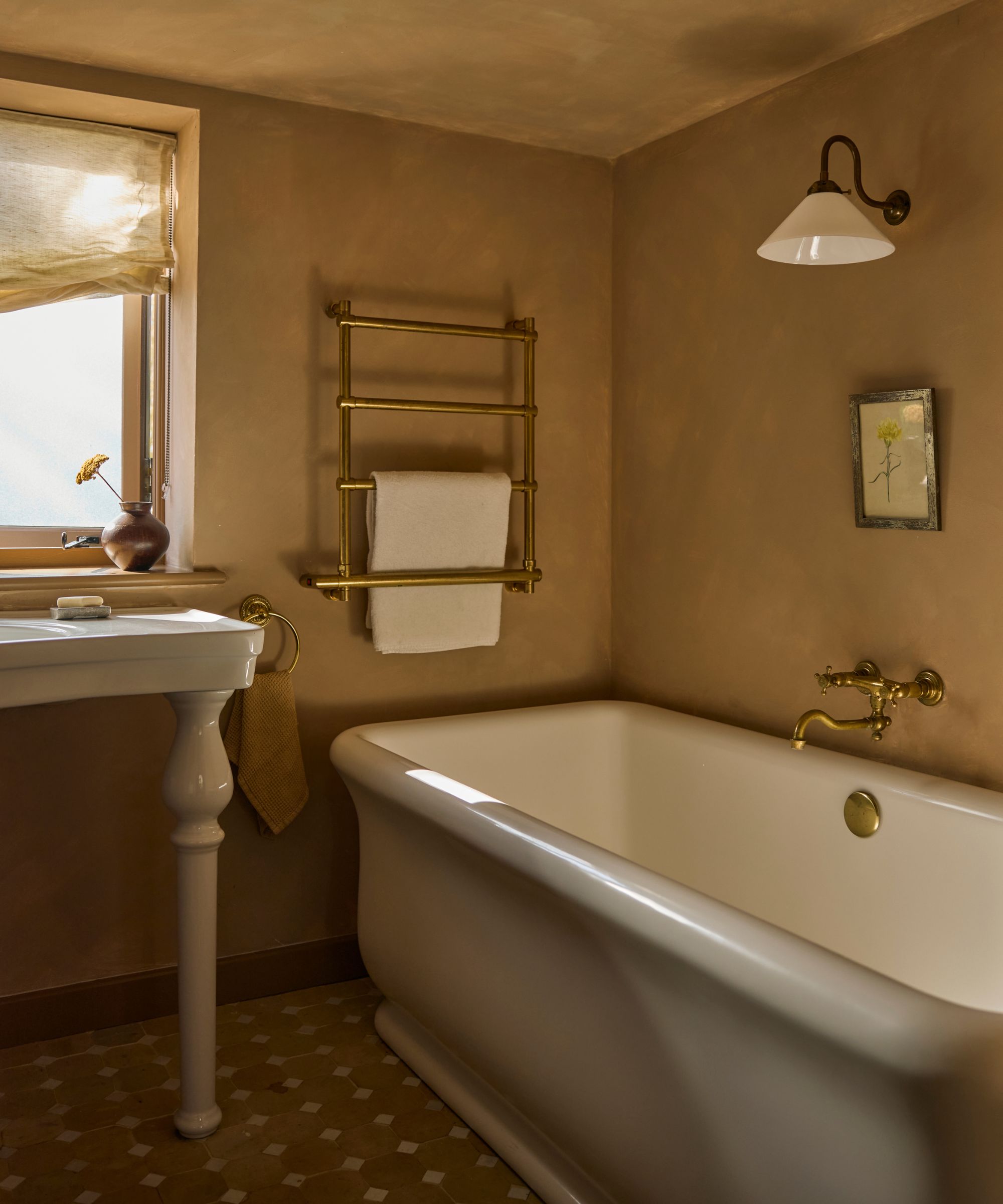 tiny home bathroom with warm neutral limewash walls, a large bathtub, and a freestanding sink