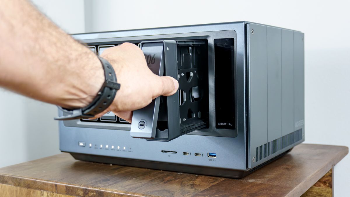 A person removing one of the drive enclosures from the Ugreen iDX6011 Pro