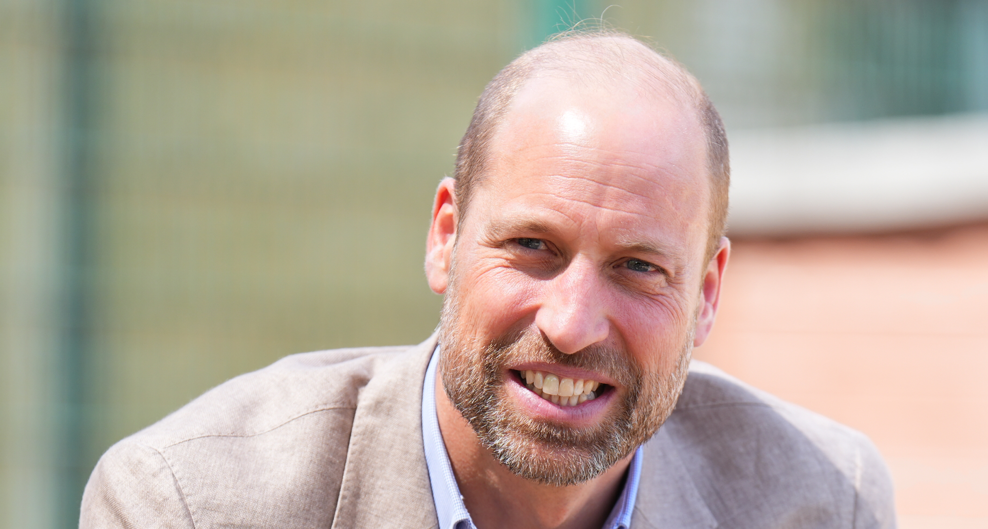 Prince WIlliam smiling in a suit outside