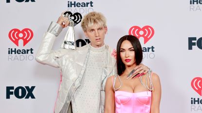 Machine Gun Kelly, winner of the Alternative Rock Album of the Year award for 'Tickets To My Downfall,’ and Megan Fox attend the 2021 iHeartRadio Music Awards