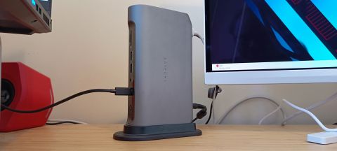 A grey Satechi Thunderbolt 4 dock sitting on a wooden desk