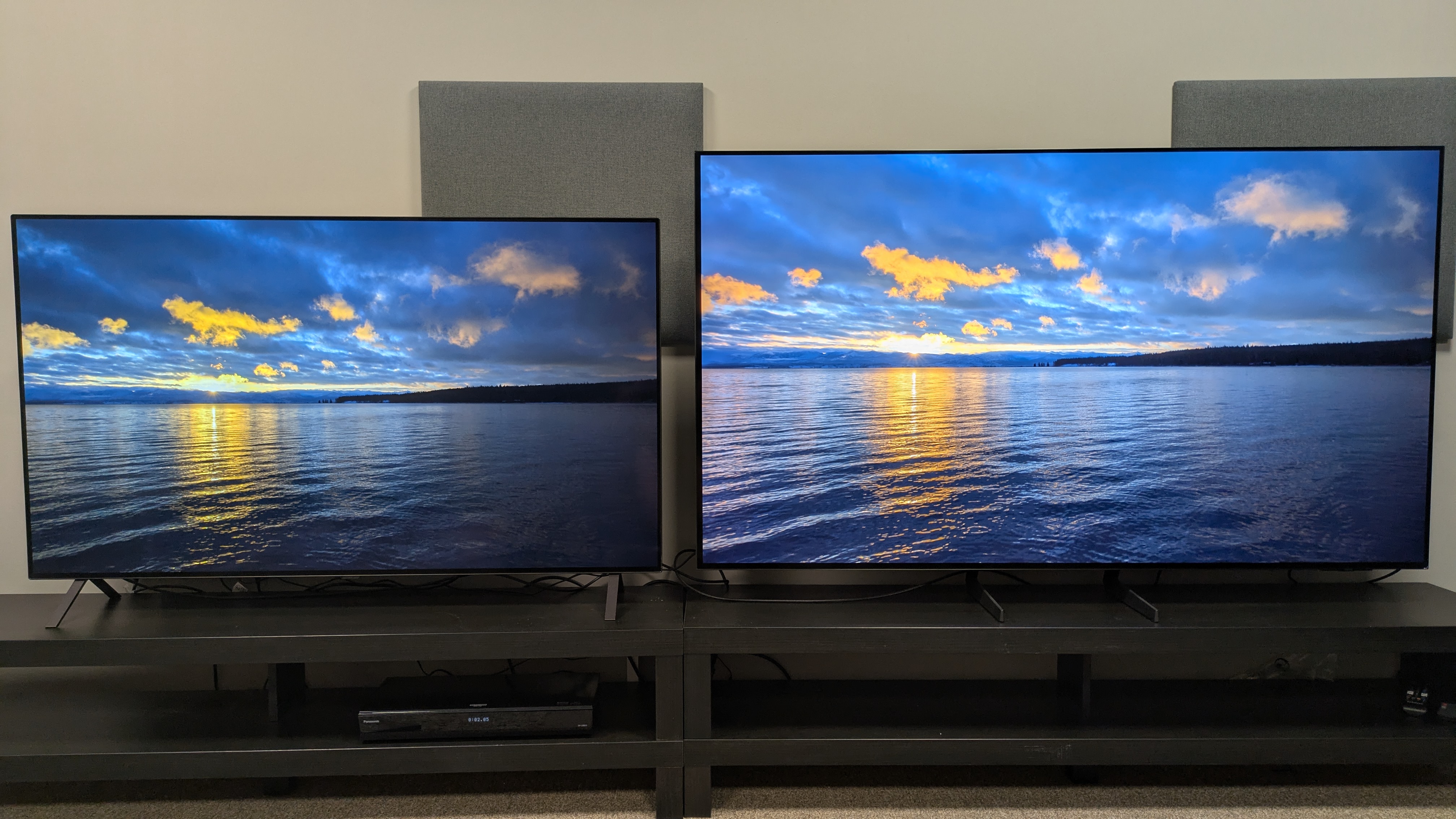 LG B5 (left) and Samsung S85F (right) showing sunset over lake on screen