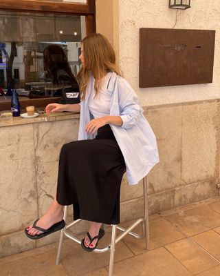 Woman in button-down and black skirt.