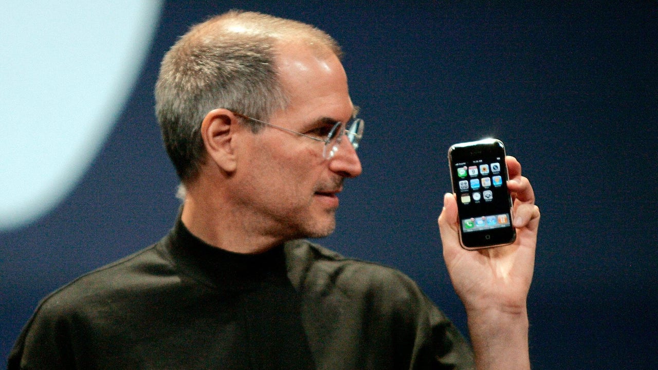 Image of Steve Jobs holding the first iPhone