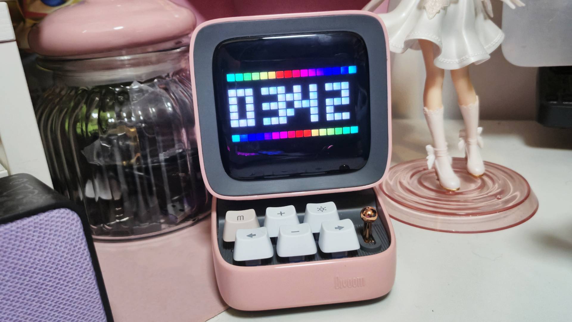 Photo by Rosalie Newcombe of the Divoom speaker sitting on a desk on pink accessories.