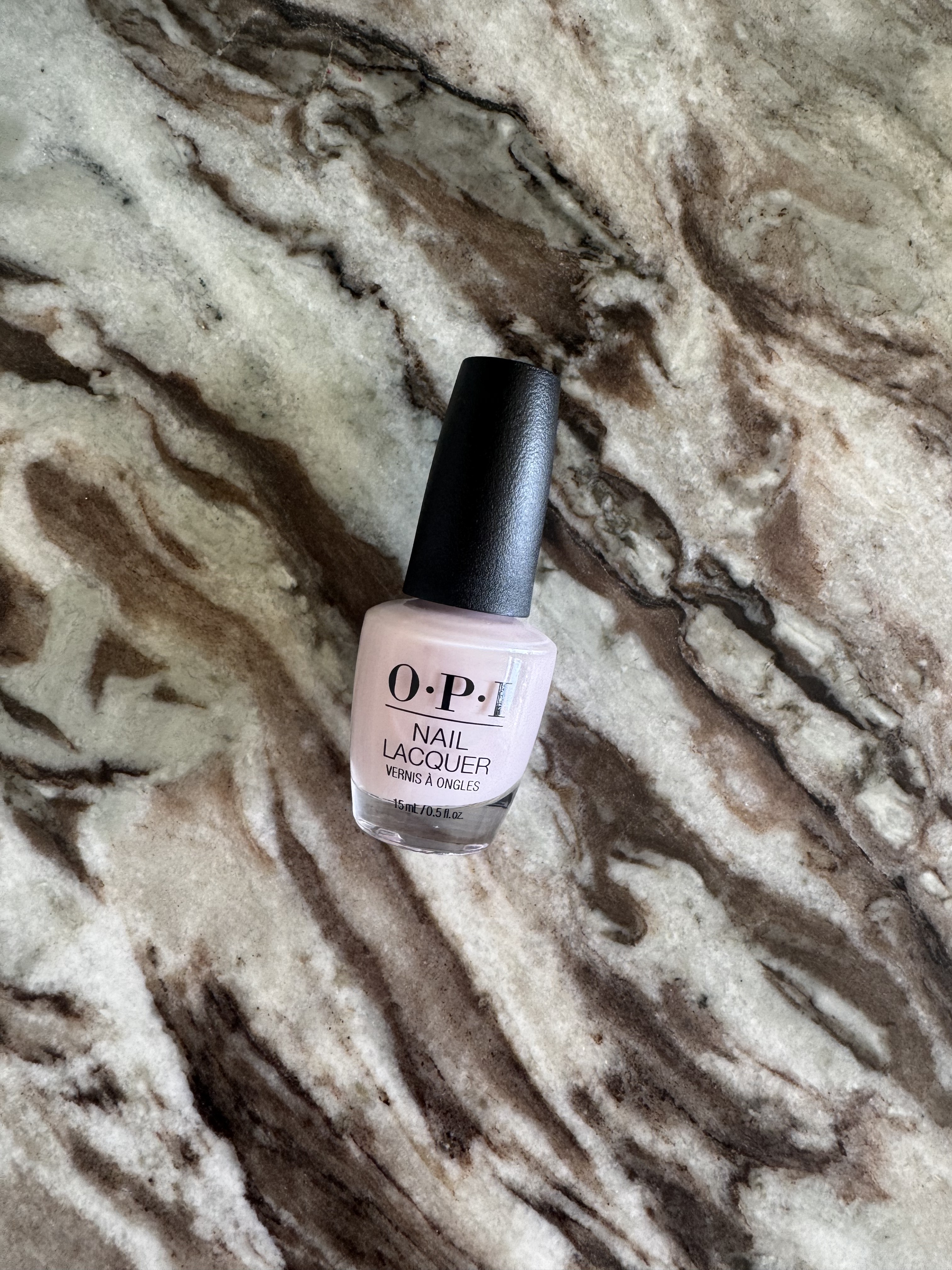 The OPI'm a Bubble Bunny nail polish on a marble table