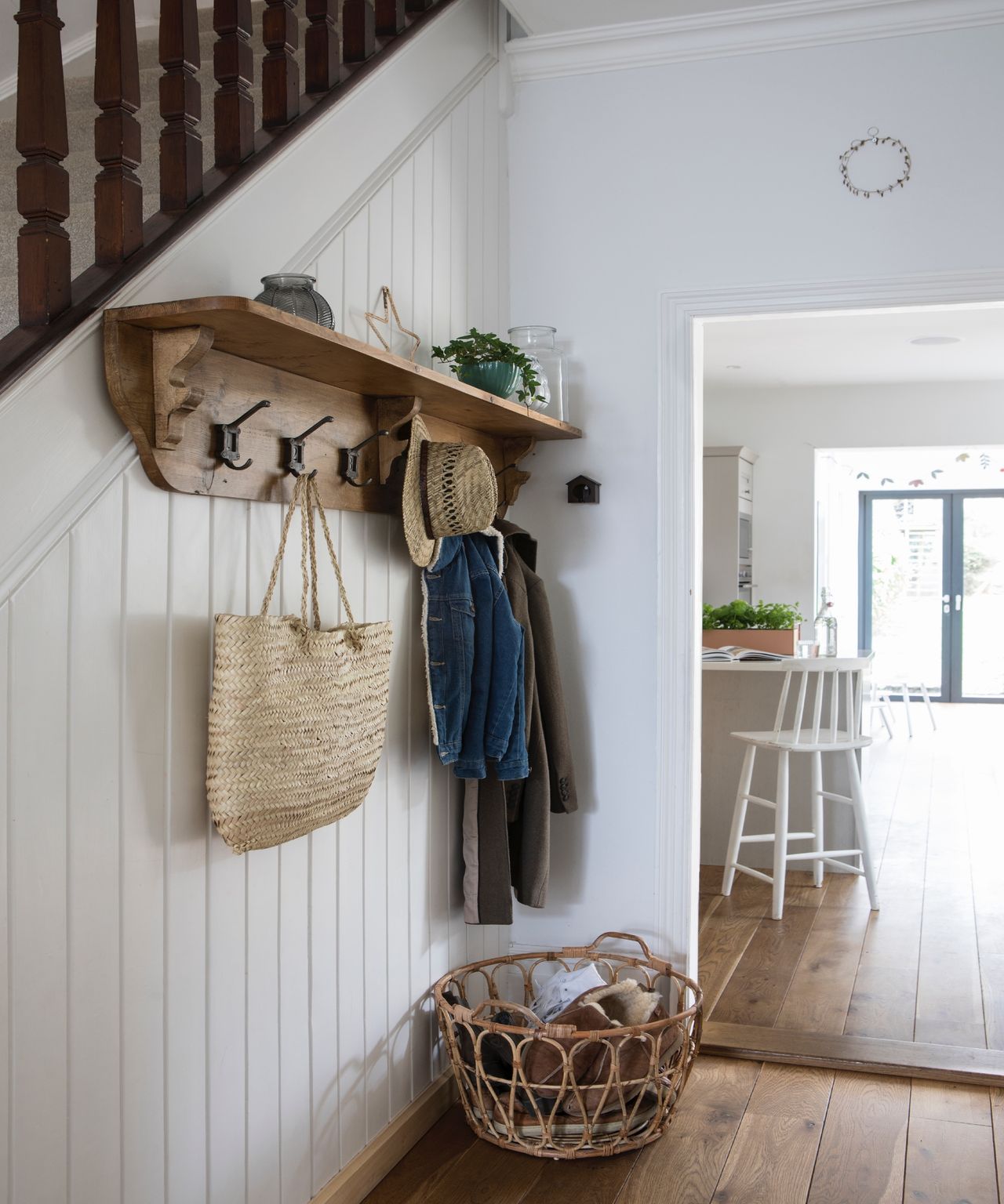 Entryway with wall shelf on white paneled wall